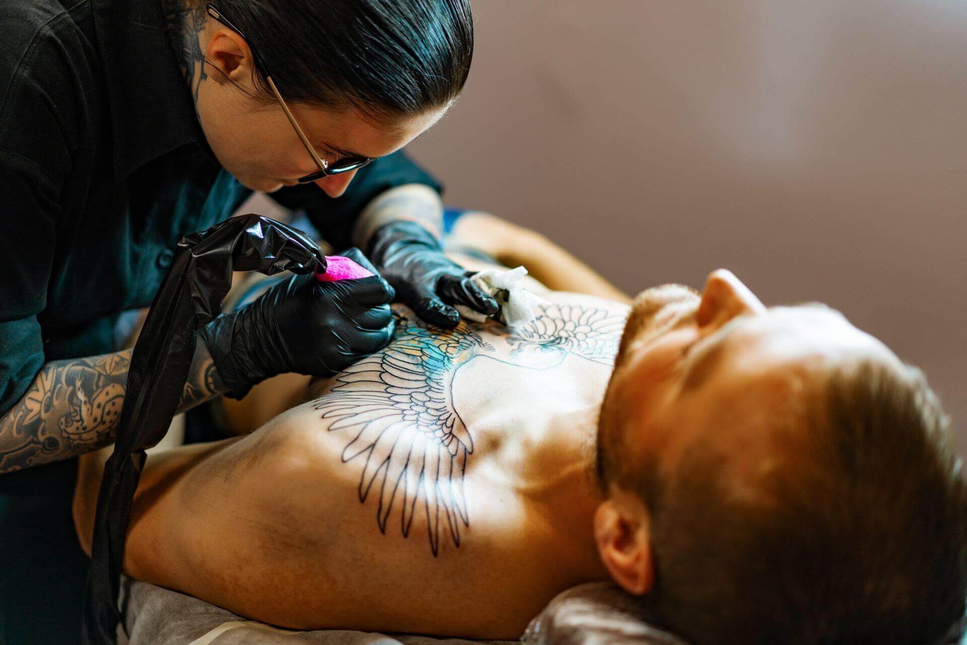 man in pain getting a tattoo