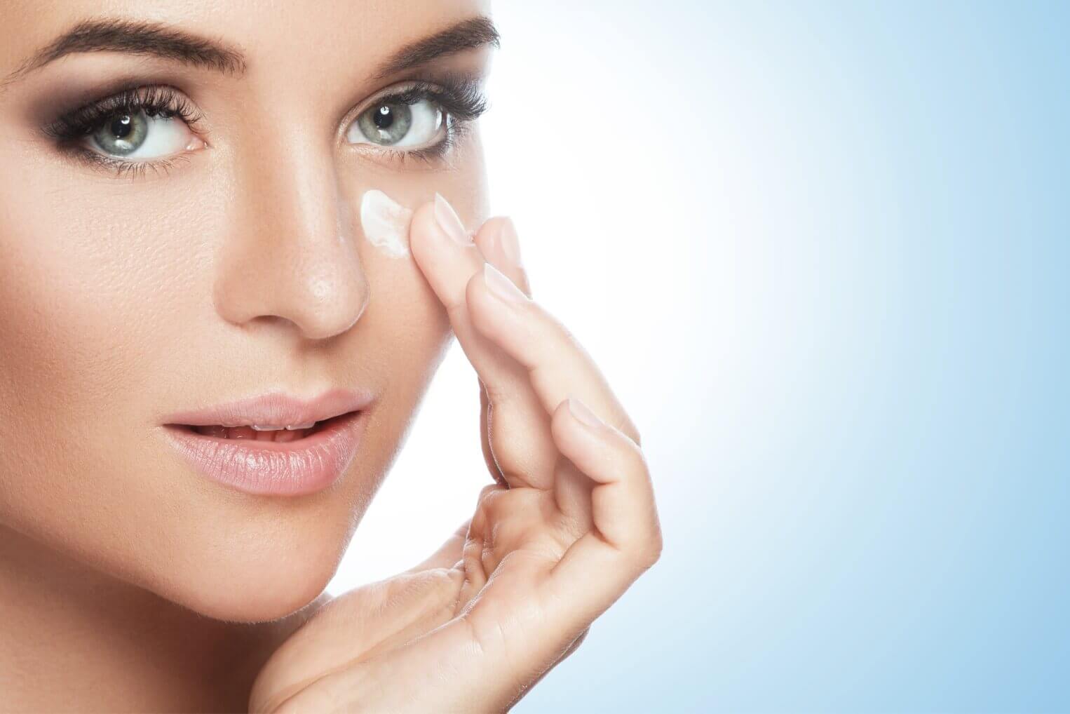 Woman rubbing skincare cream on face