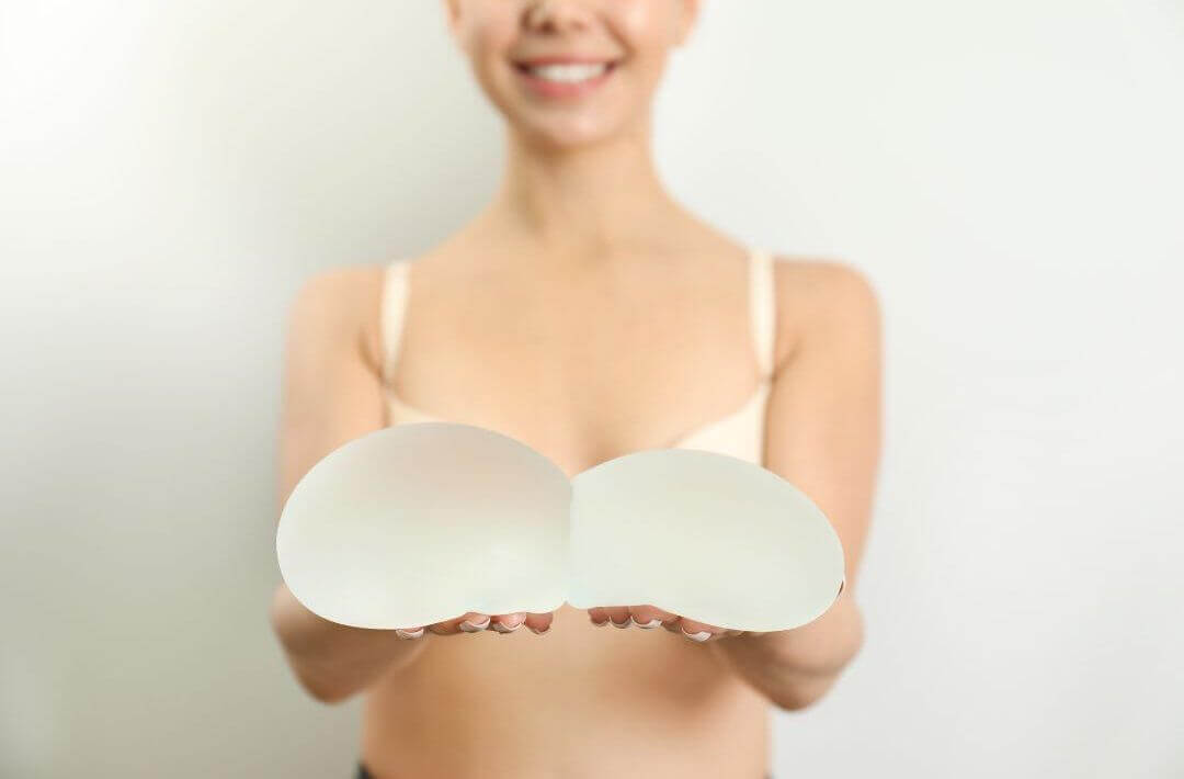 woman holding breast implants