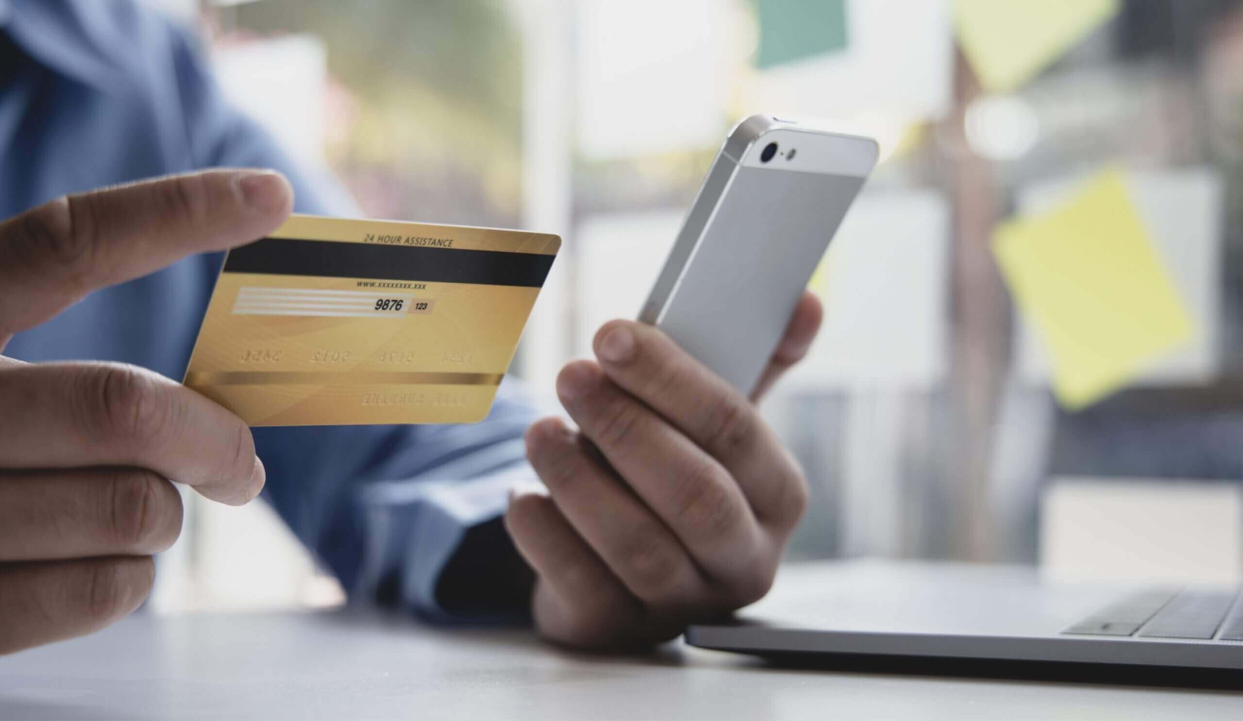 Man making online payment on his phone, using his credit card